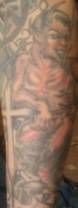 Devil Leaning on Cross Tattoo