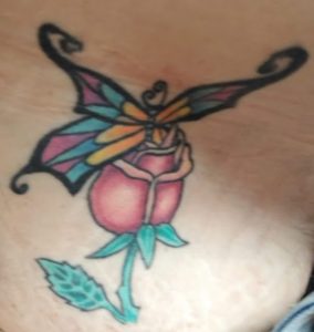 Rose with butterfly coming out of it tattoo