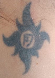 Tribal sun with D in the middle tattoo