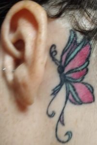 Butterfly next to ear tattoo